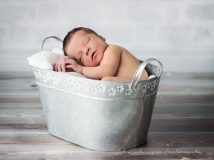 Fotografia noworodka osiedle Złotego wieku. Noworodek chłopczyk śpi w metalowej wanience.Newborn photographer Cracow