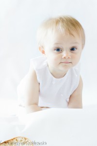 Fotografia dziecięca w Krakowie. Portret niemowlęcia dziewczynki na białym tle. Portret high key.
