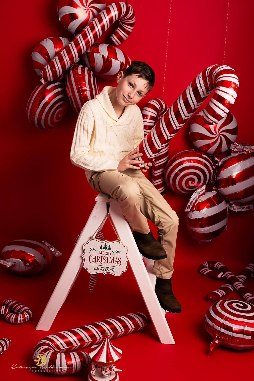 mini sesje świąteczne Kraków. Sesja chłopca na czerwonej nowoczesnej scence