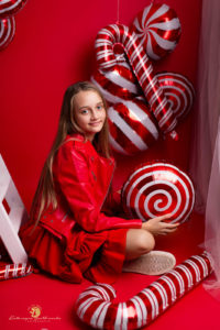 sesja świateczna krakow . sesja dziewczynki w studio na czerwonym tle z balonami w kształcie cukierków