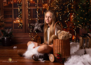 sesja świateczna krakó 2025.Zdjecie dziewczynki z sesji światecznej 2025 w studio On The Moon w Krakowie, Zdjecie na ciemno brązowej scence ze światelkami